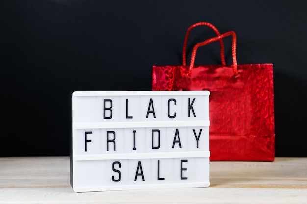 Black Friday sale Red shopping bag and lightbox on a dark background