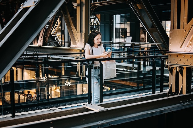 Black friday sale young latina woman with shopping bags and cell phone standing in modern shopping