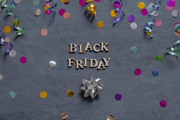 Black Friday text with holiday tinsel flat lay on dark background