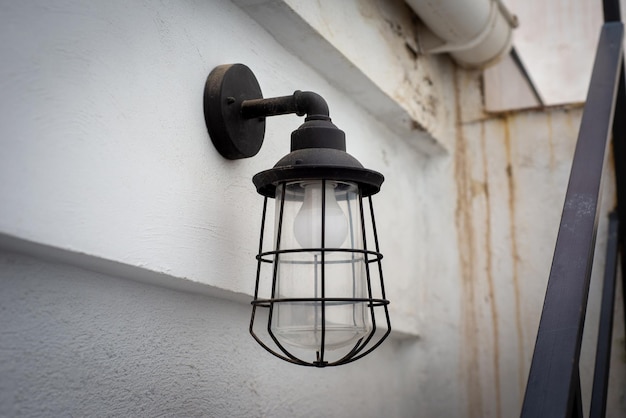 Black garden wall light hanging on a white wall