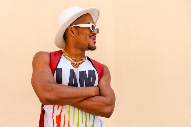 Black gay man at pride party on cream wall LGBT flag facing right