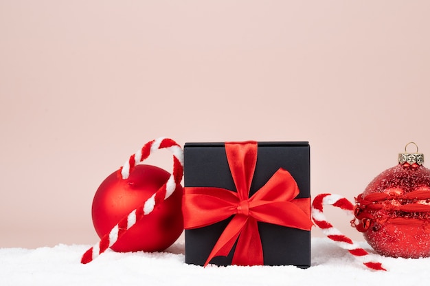 Black gift box with red bow on Christmas decorations background. Shopping concept. High quality photo