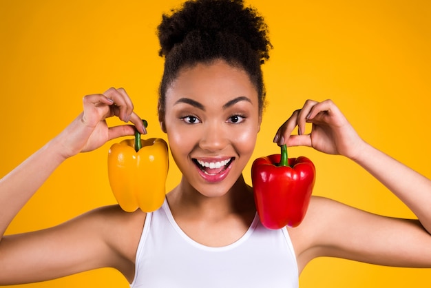 Black girl smiles and puts pepper on her shoulders.