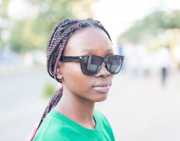 Black girl with sunglasses on city street