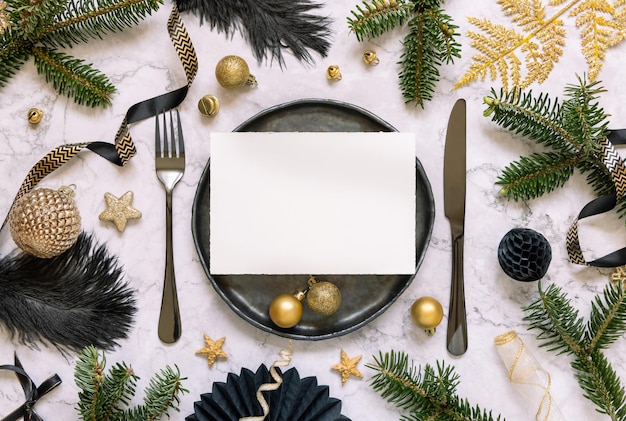 Black and golden Christmas Table setting with a card ornaments and fir tree branches Mockup