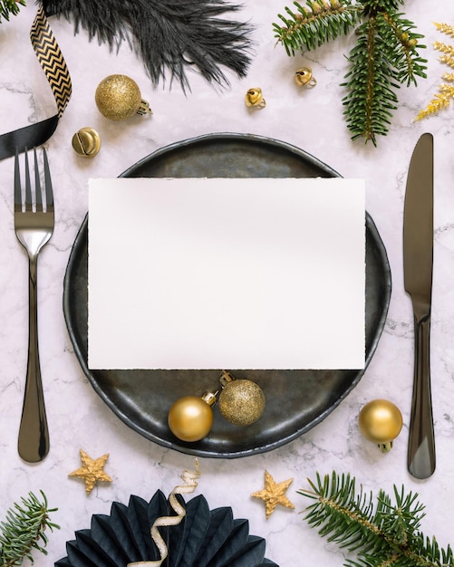 Black and golden Christmas Table setting with a card ornaments and fir tree branches Mockup