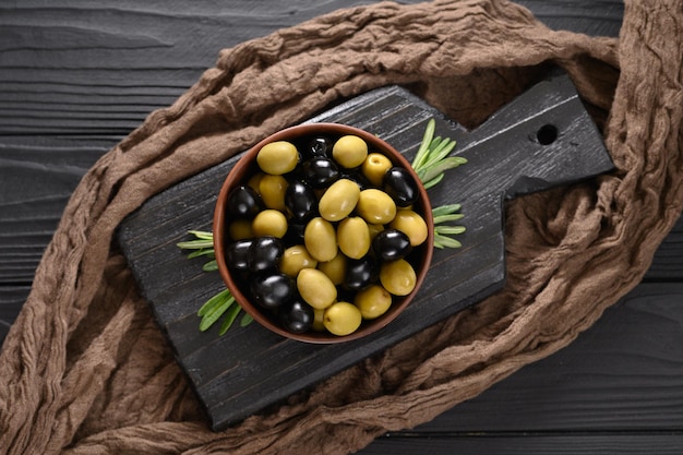 Black and green olives on a dark wooden black background