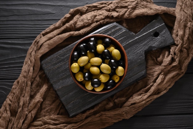 Black and green olives on a dark wooden black background