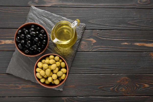 Black and green olives on a dark wooden rustic background