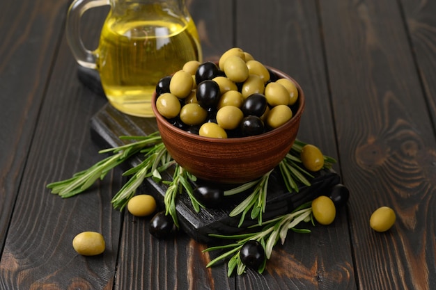 Black and green olives on a dark wooden rustic background