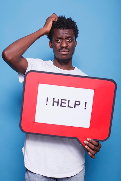 Black guy holds red speech bubble sign