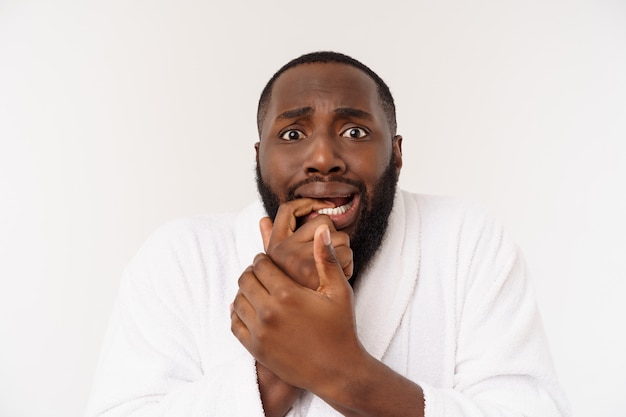 Black guy wearing a bathrobe pointing finger with surprise and happy emotion. 