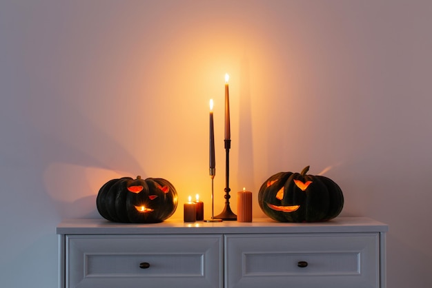 Black halloween pumpkin with burning candles in white interior