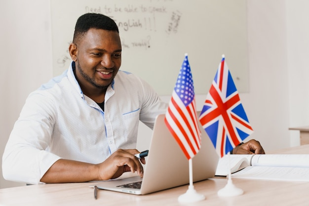 Black handsome man uses his laptop for online work according social distancing