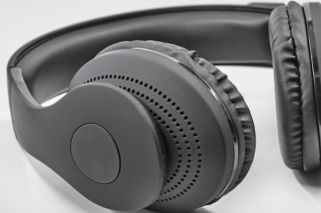 Black headphones lie on white background