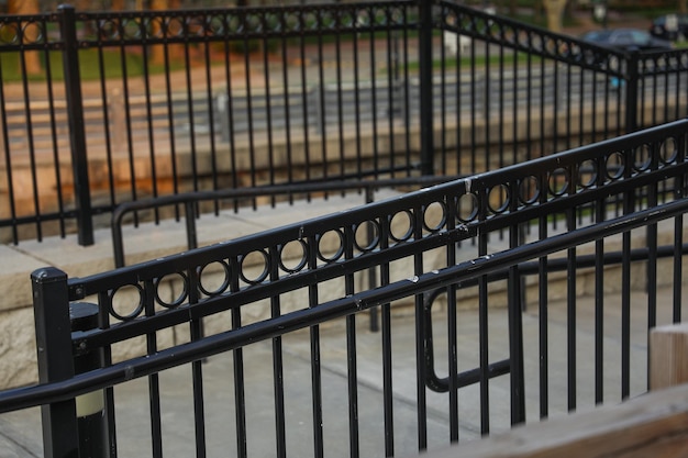 A black iron fence with a decorative design in the center.