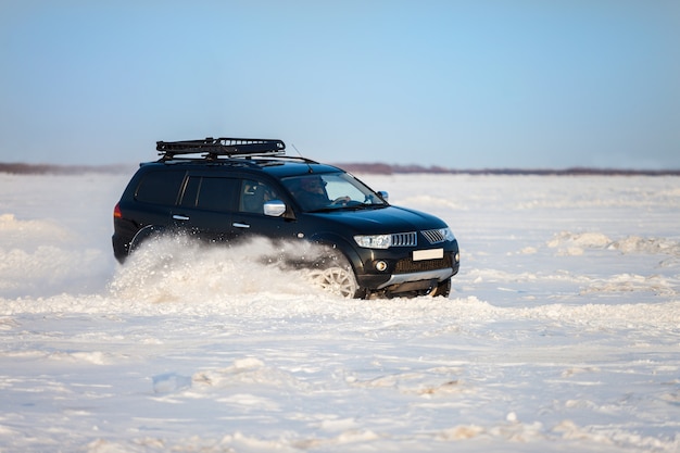 Black japanese SUV moving fast on snow