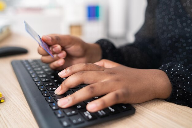 Black keyboard from computer desk in office secretary woman employee tapping fingers on keys