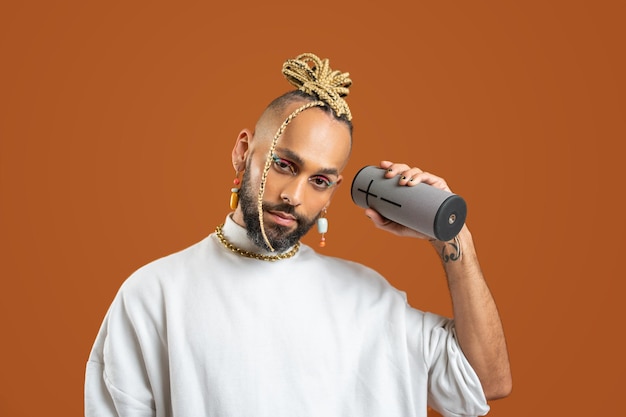 Black latin gay man isolated on orange background