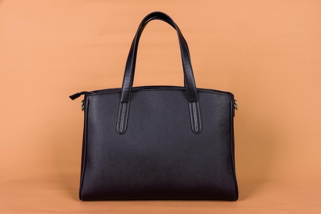 A black leather bag on an orange background