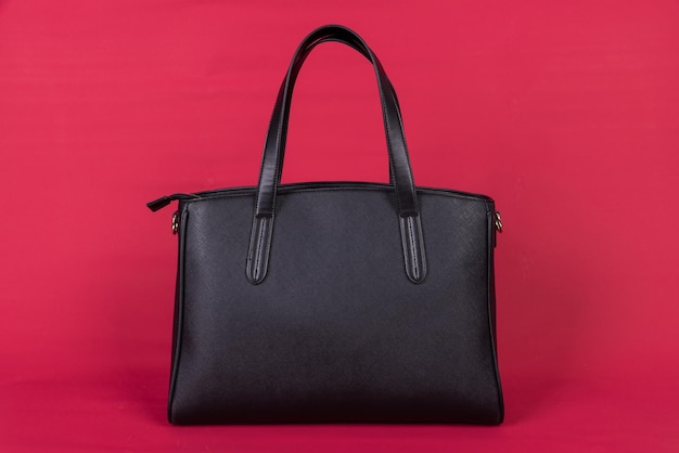 A black leather bag on a red background