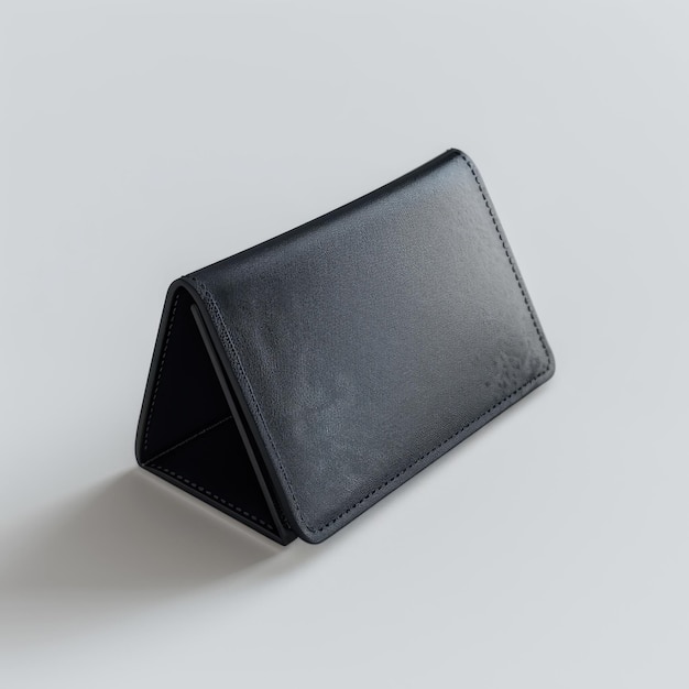 Black leather triangular wallet on plain surface