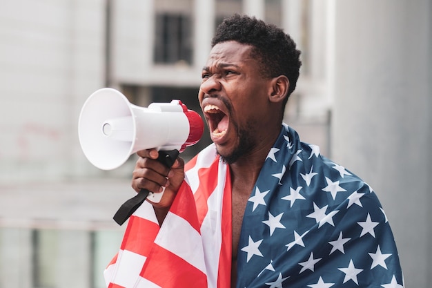 Black lives matter concept Aggressive african american guy with usa flag protests