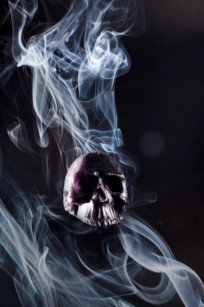 Black magic on hand with smoke on the skull.