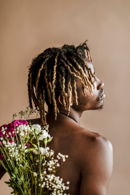 Black man carrying a bouquet of flowers on his back