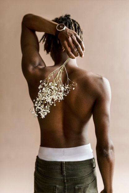 Black man carrying a bouquet of flowers on his back