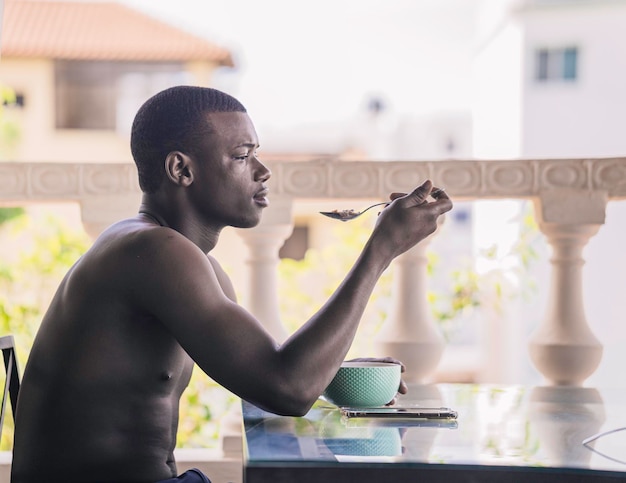 Black man having breakfast on hotel terrace