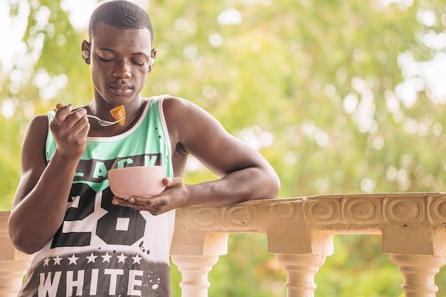 Black man having fruit for breakfast on the terrace