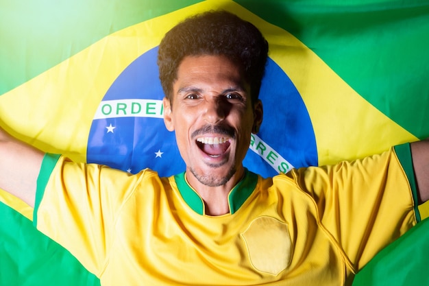 Photo black man holding brazil flag behind celebrating