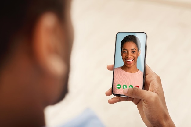 Black man holding cellphone in hand video calling friend