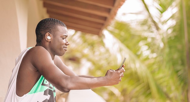 Black man looking at smart phone on terrace