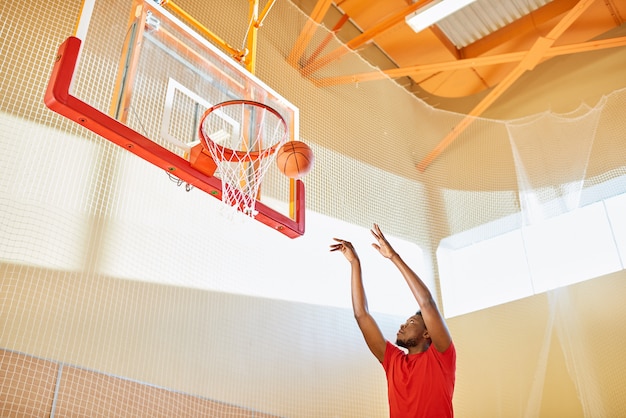 Black man shooting ball into basket