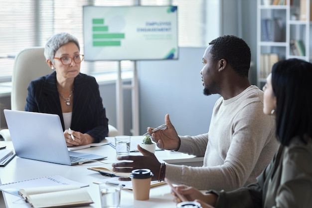 Black man talking to female manager during meeting in office