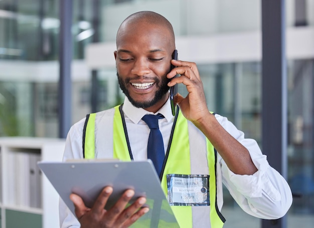 Black man with clipboard phone call for communication during inspection safety check and compliance Logistics or construction with smartphone tech and checklist for business quality assurance