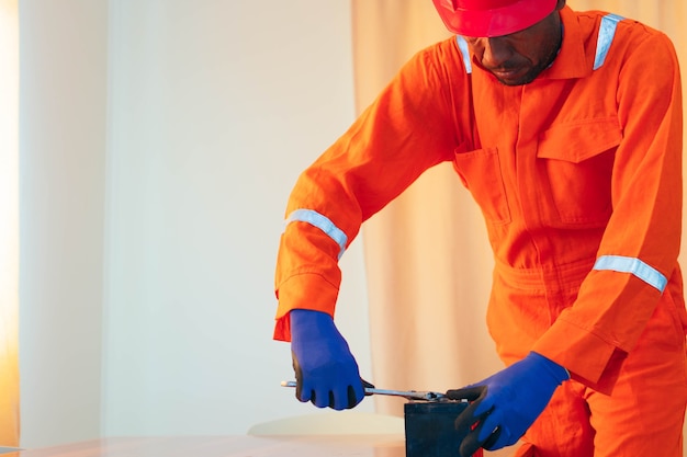 Black mechanic working on a house