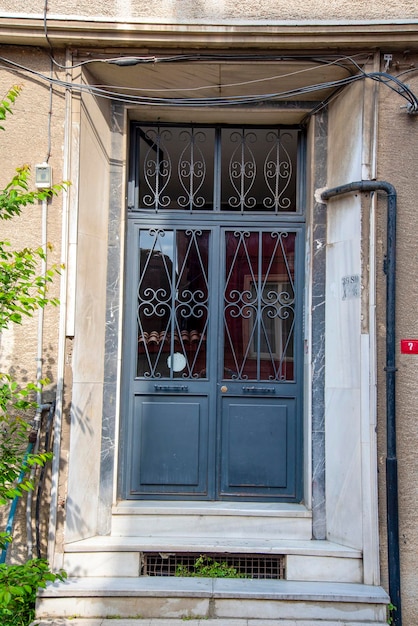 Black metal door with glass and white facade