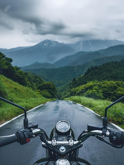 Black motorcycle rides on winding road through green landscape with snowcapped mountains in