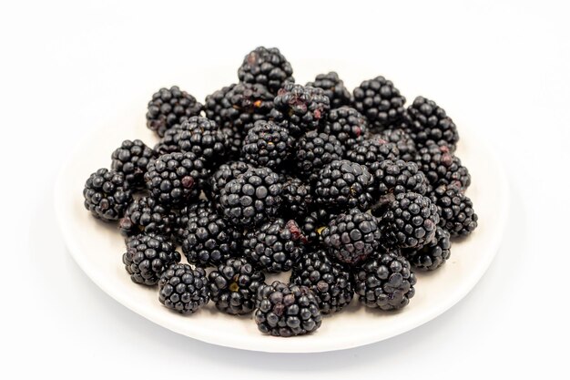 Black mulberry isolated on white background Fresh and juicy black mulberry on the plate Organic food close up