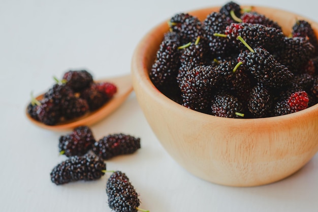 Black mulberry in a wooden cup It is a fruit of the berry family that has health benefits