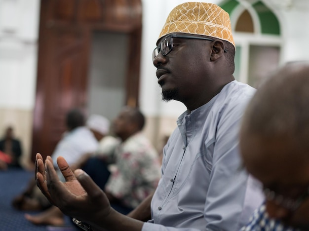 Black Muslim adult man praying inside mosque on Friday prayer