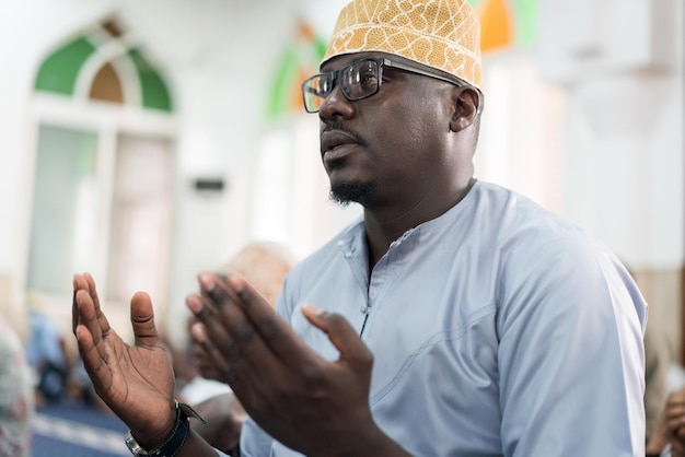 Black Muslim adult man praying inside mosque on Friday prayer