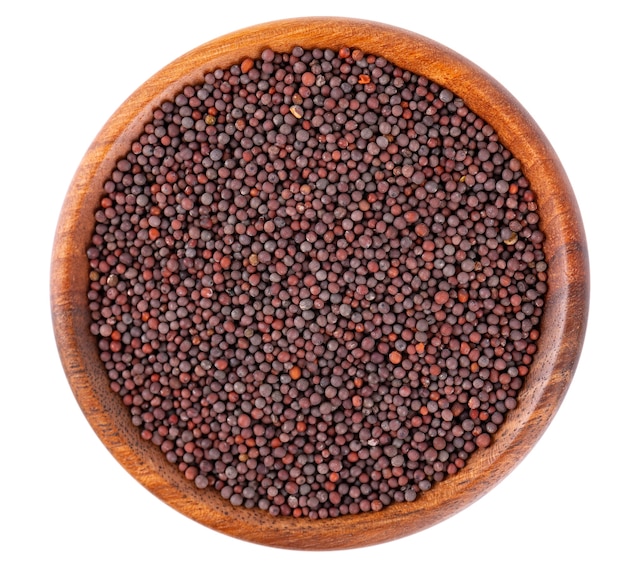 Black mustard seeds in wooden bowl isolated on white background top view