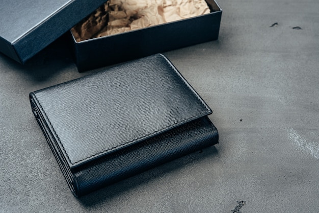 Black new leather wallet on grey concrete background