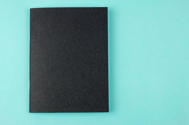 Black notebook on blue background