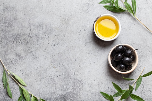 Black olives and extra virgin olive oil in little bowl with