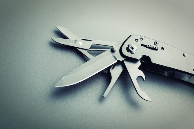 Black opened multitool knife closeup. Toned